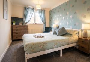 a bedroom with a bed with a blue wall at 3 Bed Semi - Sleeps 5 - Private Garden & Parking - Quiet Cul De Sac Location - Dog Friendly - Fast Wifi - Close to Motorway Access in Doncaster