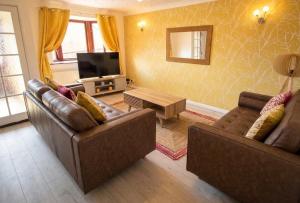 a living room with two couches and a television at 3 Bed Semi - Sleeps 5 - Private Garden & Parking - Quiet Cul De Sac Location - Dog Friendly - Fast Wifi - Close to Motorway Access in Doncaster