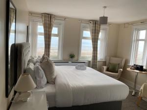 a bedroom with a large white bed with windows at 262 Ocean Manor in Blackpool