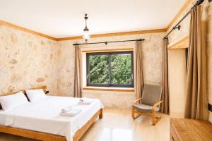 a bedroom with a bed and a chair and a window at Han Villa in Kaş +75 photos