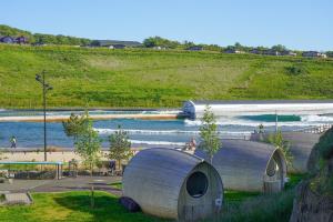a couple of round houses sitting on top of a beach at Lost Shore Surf Resort in Ratho
