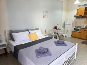 a bedroom with a large bed with two towels on it at Angela Studio in Ipsos +17 photos