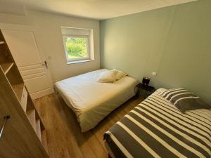 a small bedroom with two beds and a window at Les Gîtes des Portes de Bretagne in La Chapelle-Saint-Aubert