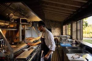a man standing in a kitchen preparing food at Fattoria di Vegi in Castellina in Chianti