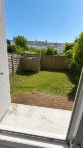 an open door to a yard with a fence at Le Cocooning - 4 voyageurs - Jardin,Terrasse in Saint-Nazaire