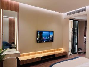 a living room with a tv on a wall at Voyage Expo Suites in Riyadh