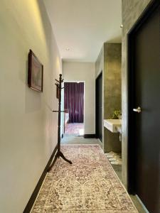 a hallway with a door and a bathroom with a sink at Rumah Cermin in Langkawi Intl