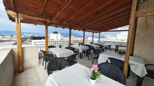 a restaurant with tables and chairs on a balcony at Achilleion-Edipsos in Loutra Edipsou