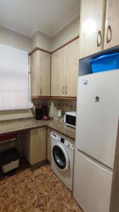 a kitchen with a white refrigerator and a washing machine at El Faro-Beach in Cullera