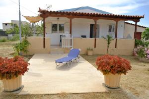 a blue chair sitting in front of a house at Small farmhouse by M in Egina
