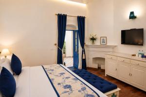 a bedroom with a bed and a desk and a television at Pine Retreat - A Premium Heritage Property in Mussoorie