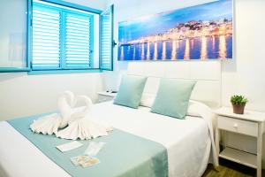 a bedroom with a bed with two swans on it at Hostal Sunset Ibiza in San Antonio