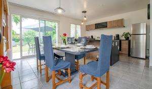 a kitchen and dining room with a table and blue chairs at La caillotine in Rosières-près-Troyes
