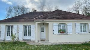 a white house with a brown roof at La caillotine in Rosières-près-Troyes