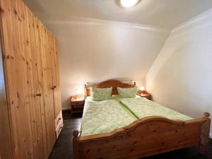 a bedroom with a wooden bed with two pillows at Hof Döttgebüll in Aventoft