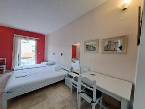 two beds in a room with red walls at Areti & Maria Apartments in Gythio
