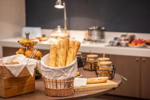 a table with a basket of french fries and bread at Elema Hotels Beauvais ex Hostellerie Saint Vincent Beauvais Aeroport in Beauvais
