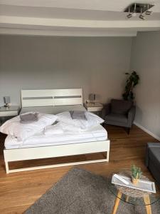 a bedroom with a white bed and a couch at Fachwerk FeWo Schoningen in Uslar