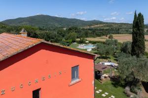 an orange building with a view of a field and trees at Zuccherini in Buriano