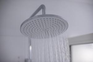 a shower with a curtain hanging from a ceiling at Elema Hotels Beauvais ex Hostellerie Saint Vincent Beauvais Aeroport in Beauvais +39 photos