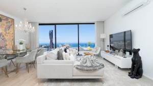 a living room with a white couch and a dining room at Villa Lilian by LovelyStay in Arco da Calheta
