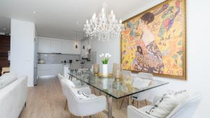 a dining room with a glass table and white chairs at Villa Lilian by LovelyStay in Arco da Calheta