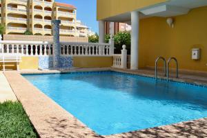 a swimming pool in front of a building at Xaloc Solo Familias Serviplaya in Playa de Xeraco