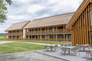 a building with tables and chairs in front of it at Butični Hotel Sončno Polje in Moravske-Toplice