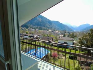 a balcony with a view of a pool and mountains at petiros in Arta Terme