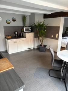 a kitchen with white cabinets and a table at Fachwerk FeWo Schoningen in Uslar