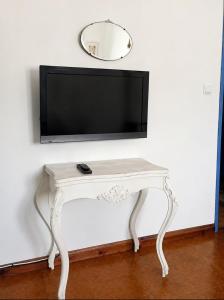 a white console table with a television on a wall at Sunset Vista Apartment B in Mação