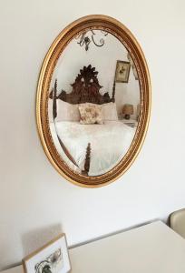 a mirror hanging on a wall above a bed at Sunset Vista Apartment B in Mação