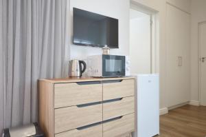 a dresser with a tv on top of it at Caracal 54 Overnight for 2 in Yzerfontein