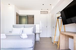 a bedroom with a bed and a flat screen tv at SIVOTA SUNSET VILLAS in Syvota