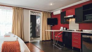 a kitchen with red walls and a table in a room at 314 on Clark Guest House in Pretoria