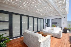 a living room with white furniture and large windows at Caracal 54 Overnight for 2 in Yzerfontein +5 photos