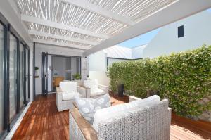 a living room with white furniture on a wooden floor at Caracal 54 Overnight for 2 in Yzerfontein