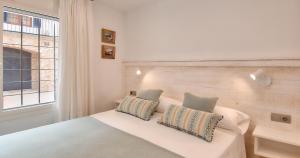 a bedroom with a white bed and a window at Sant Roc Apartments a Minute From The Beach in Calella de Palafrugell