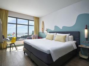 a hotel room with a large bed and a window at ibis Styles Vung Tau in Vung Tau