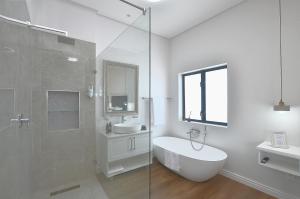 a bathroom with a shower and a sink and a toilet at Caracal 54 Overnight for 2 in Yzerfontein