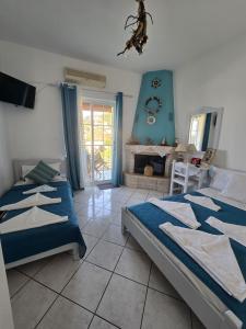 a bedroom with two beds and a fireplace at Athina Studios in Chorto