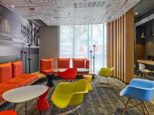 a waiting room with colorful chairs and tables at ibis Trujillo in Trujillo