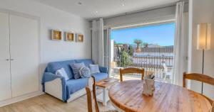 a living room with a blue couch and a table at Sant Roc Apartments a Minute From The Beach in Calella de Palafrugell