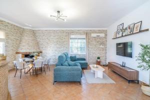 a living room with a blue couch and a table at Casa Rural Villa Manantial in La Puebla de Cazalla