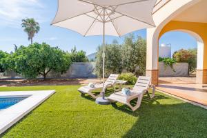 a group of chairs and an umbrella next to a pool at Casa Rural Villa Manantial in La Puebla de Cazalla