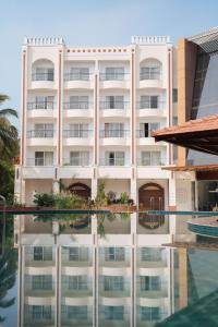 a large white building with a pool in front of it at ORYN-Celebrity Resort, Shamirpet, Hyderabad, Secunderabad, in Shamirpet