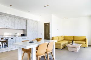 a kitchen and living room with a white table and chairs at SIVOTA SUNSET VILLAS in Syvota
