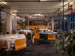 a dining room with tables and chairs in a building at ibis Styles Darmstadt in Darmstadt
