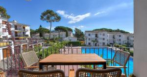 a table and chairs on a balcony next to a pool at Penyagolosa in Calella de Palafrugell