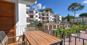 a balcony with a wooden bench on a building at Penyagolosa in Calella de Palafrugell